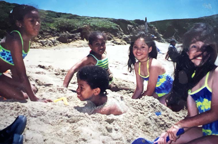 Lower graders at the beach, boy is in the sand.