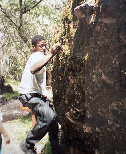 Middle school boy rock climbing
